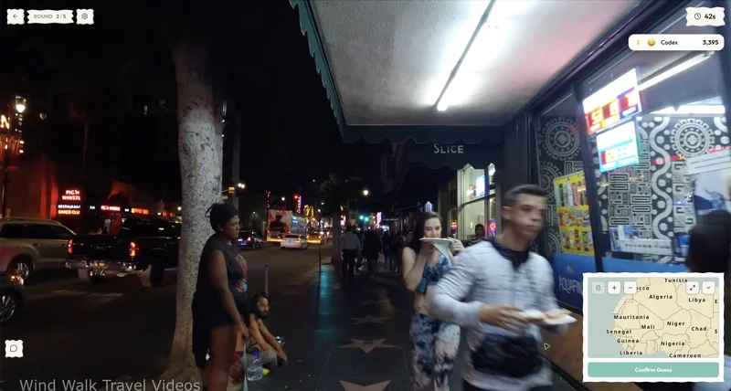 CityGuesser mid-round: a walking-tour video moving down a busy street, with the guess mini-map open